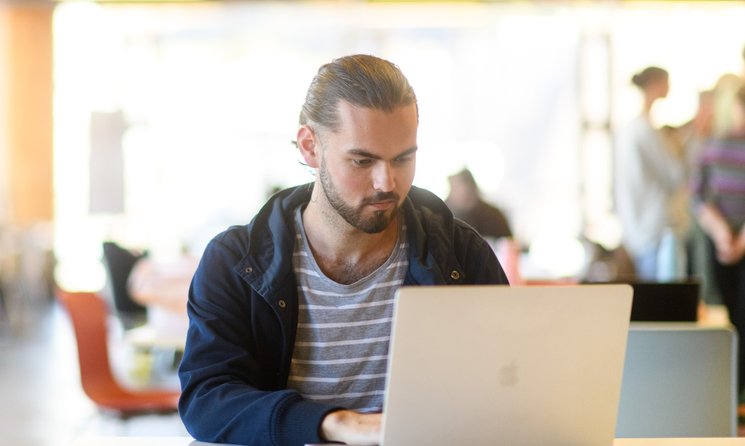 A student studying on his laptop at Massey University campus.